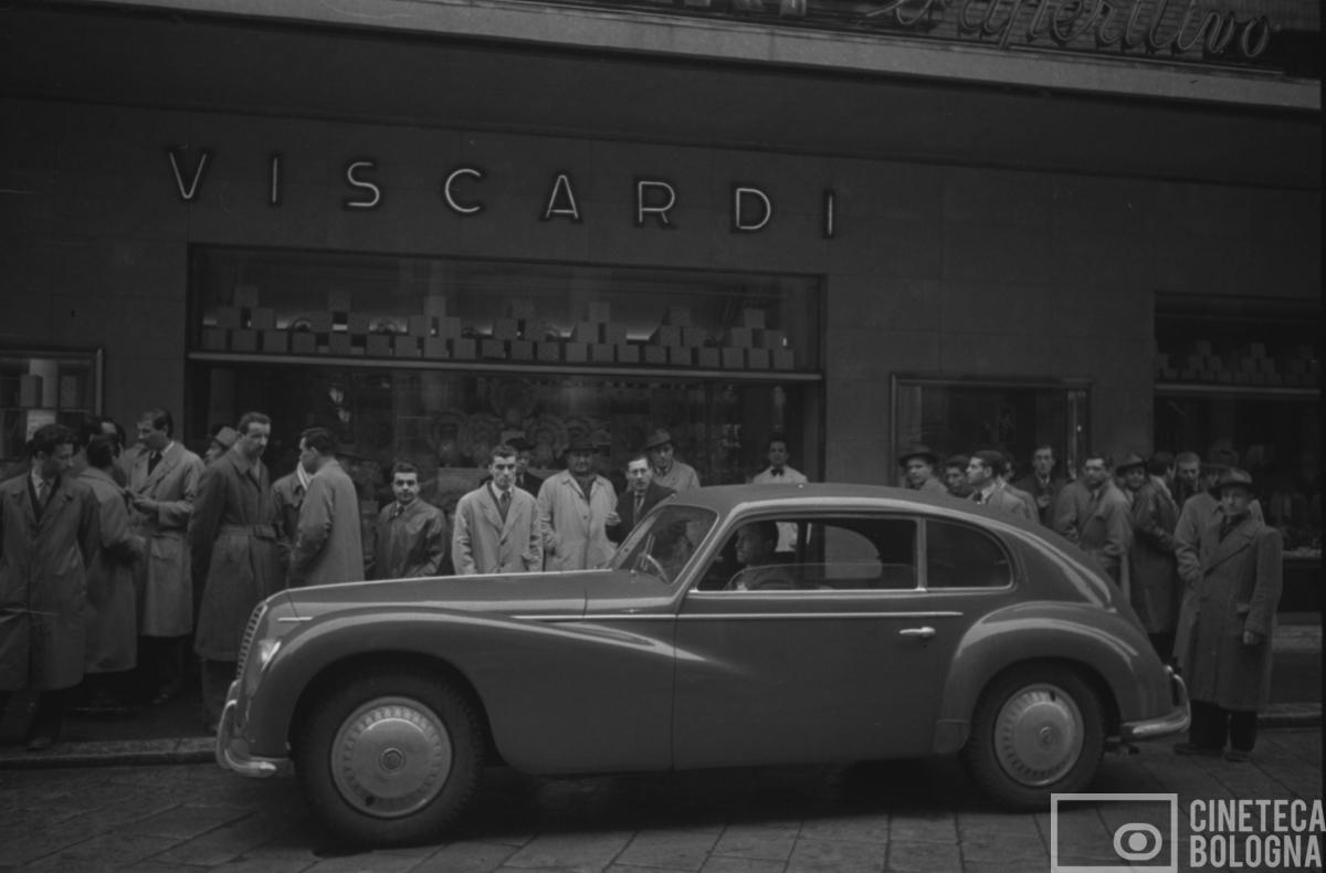 Bologna. Via Rizzoli.  Auto Alfa Romeo davanti al bar pasticceria Viscardi